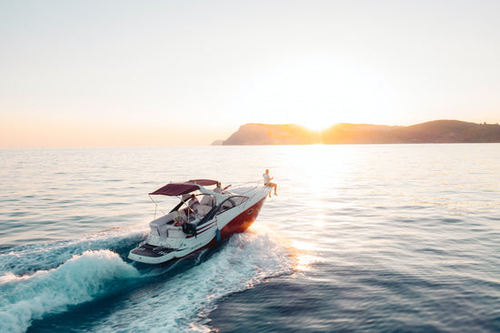 Ein Boot, dass richtig Sonnenuntergang fährt.